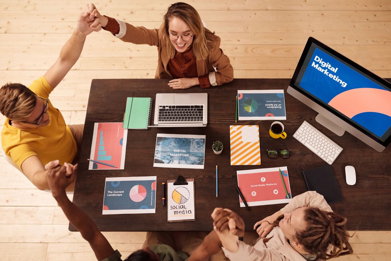 Colleagues celebrating a win in a modern digital marketing office, working together in teamwork and collaboration.
